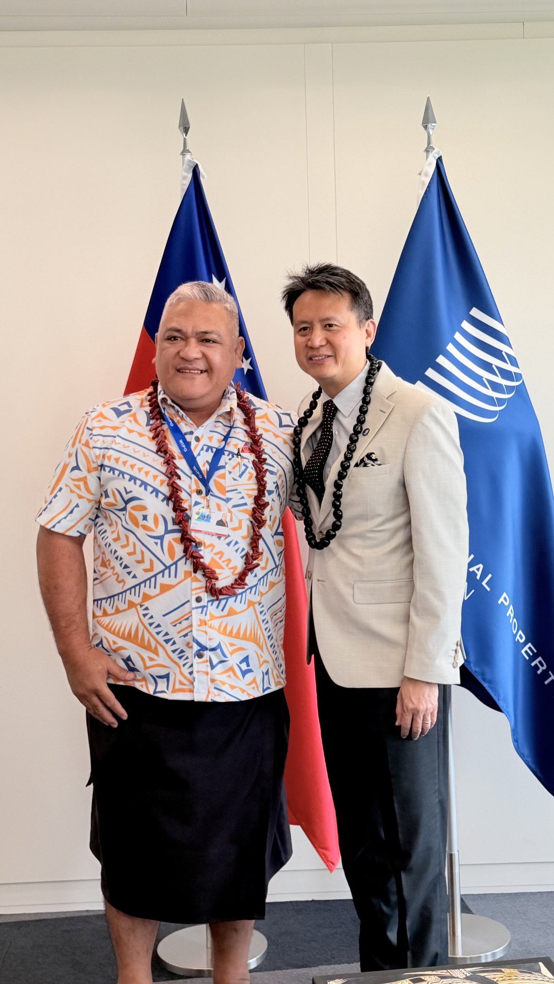 A member of the Samoa delegation with WIPO Director General Daren Tang in front of the Samoa and WIPO flags