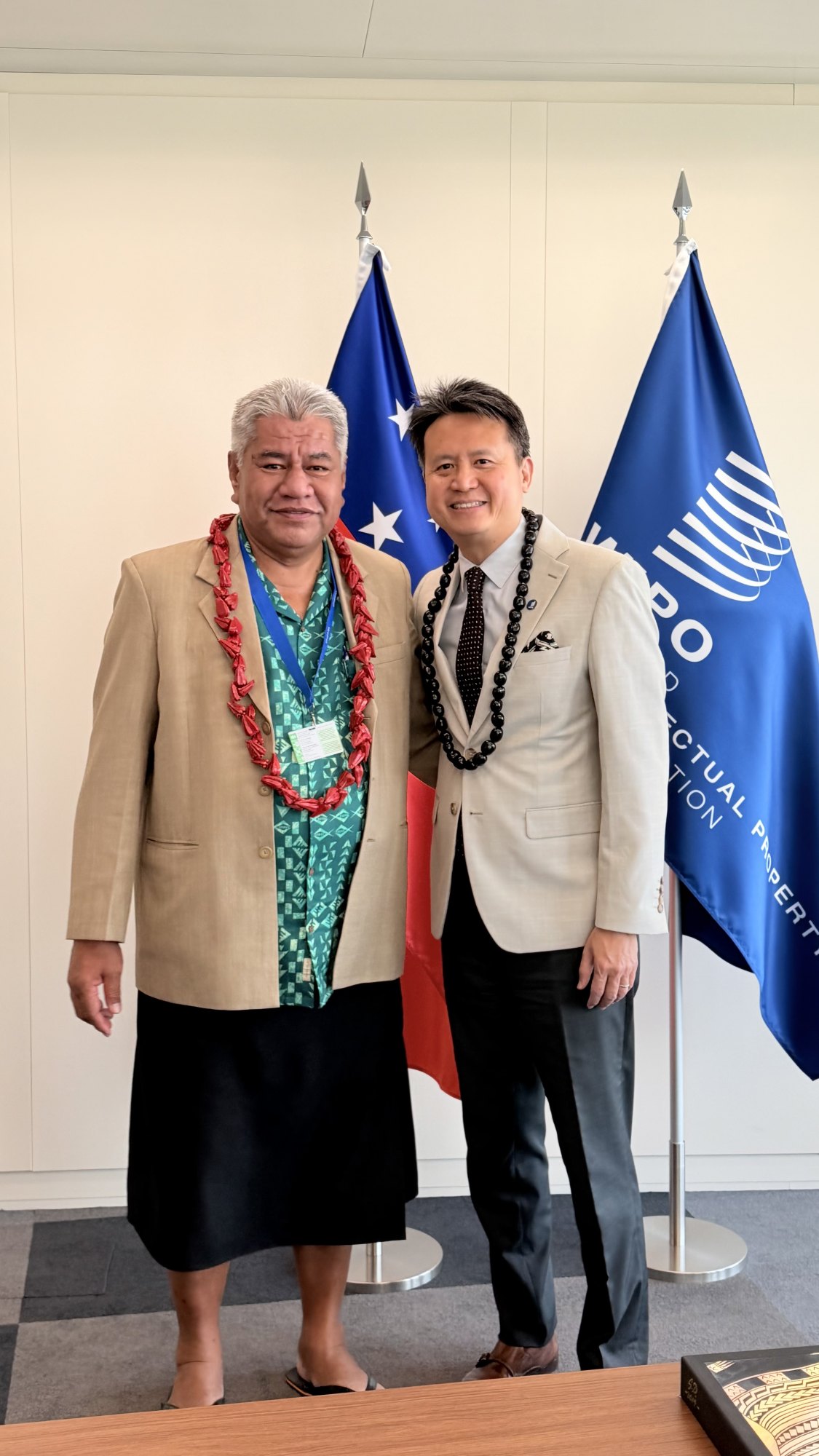 A Samoa delegate with WIPO Director General Daren Tang beside the Samoa and WIPO flags