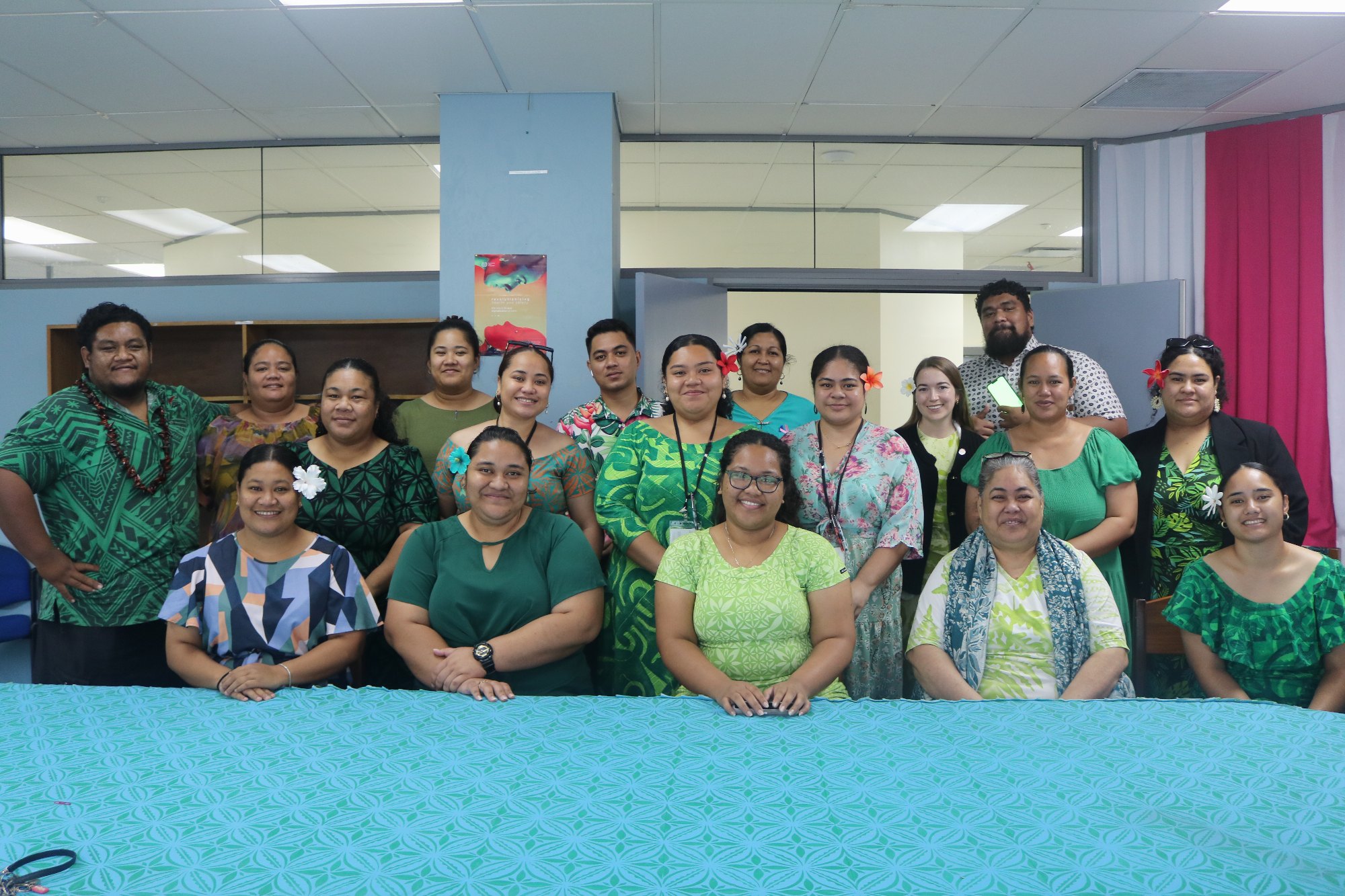 MCIL staff dressed in green gather around a conference table for Mental Health Awareness Week