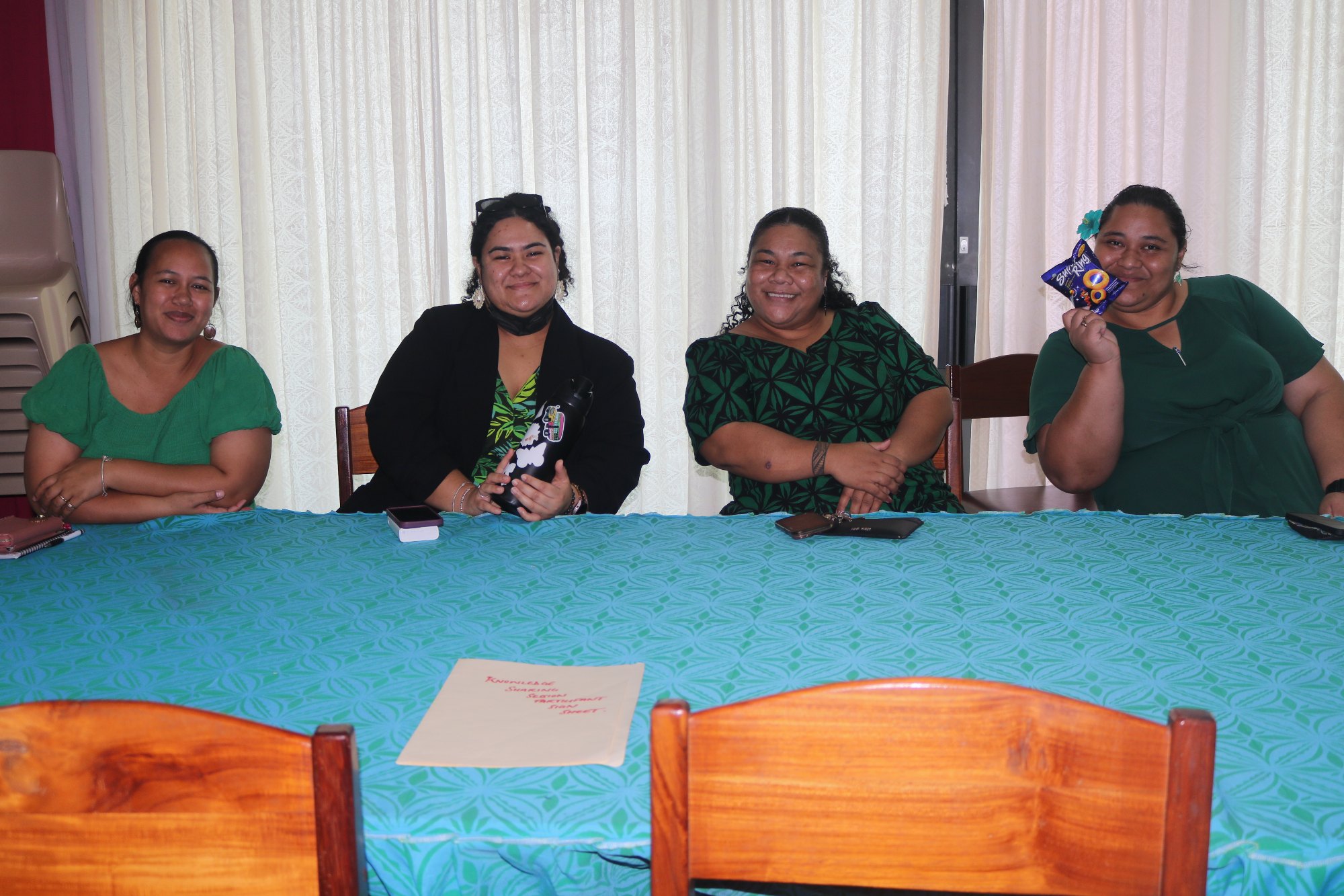 Four MCIL staff in green seated together at a table during Mental Health Awareness Week